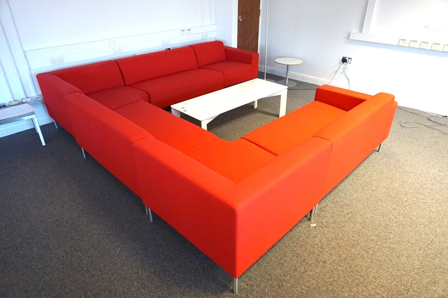 Red upholstered sectional sofa with white glass to...