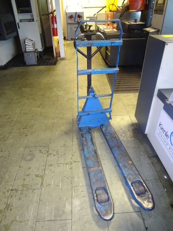 Manual pallet truck with frame attached
